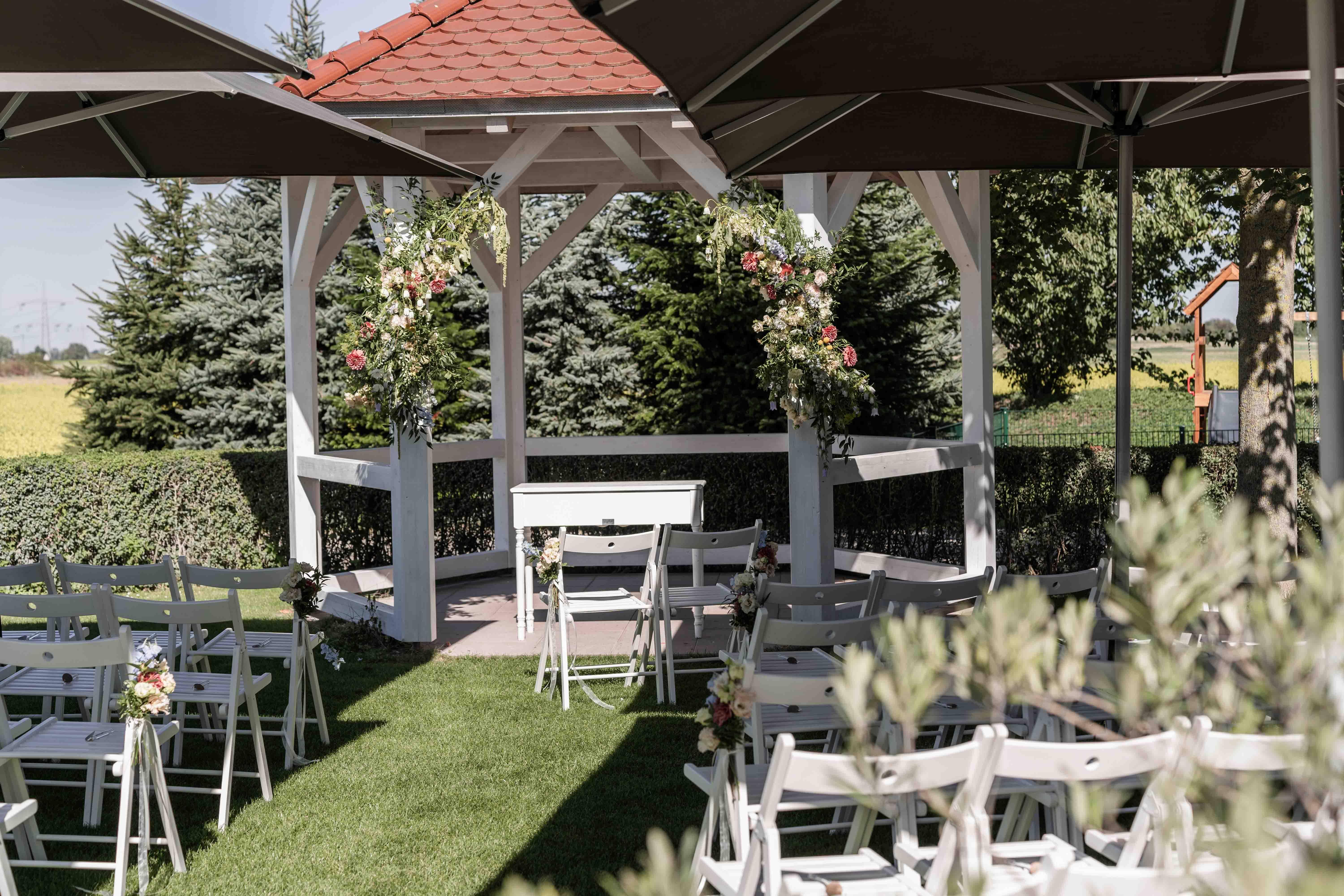 Fotografie der Lokation - Stühle der Gäste sowie das Gazebo für die freie Trauung