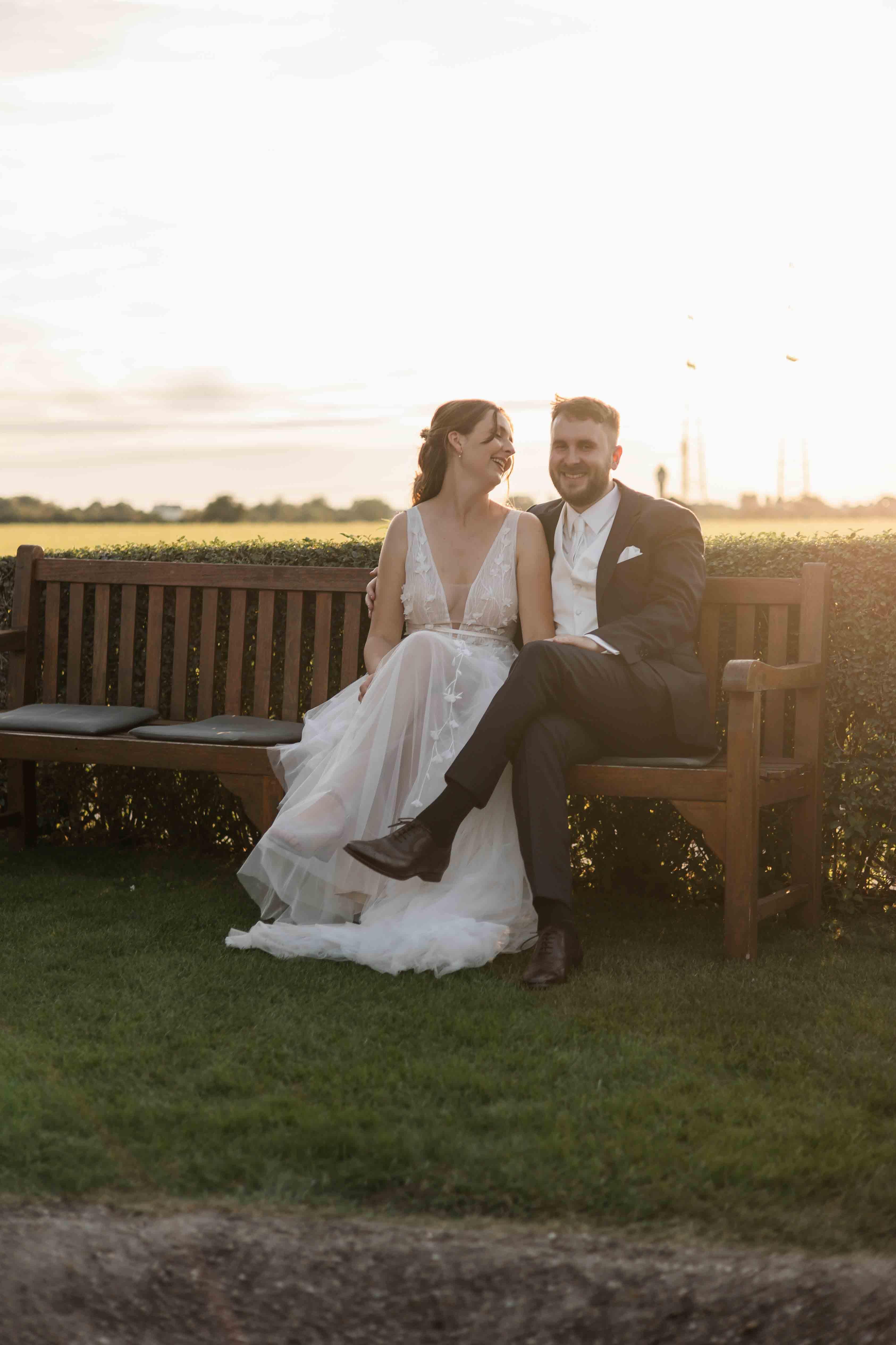 Hochzeitsfoto des Brautpaars auf einer Bank sitzend