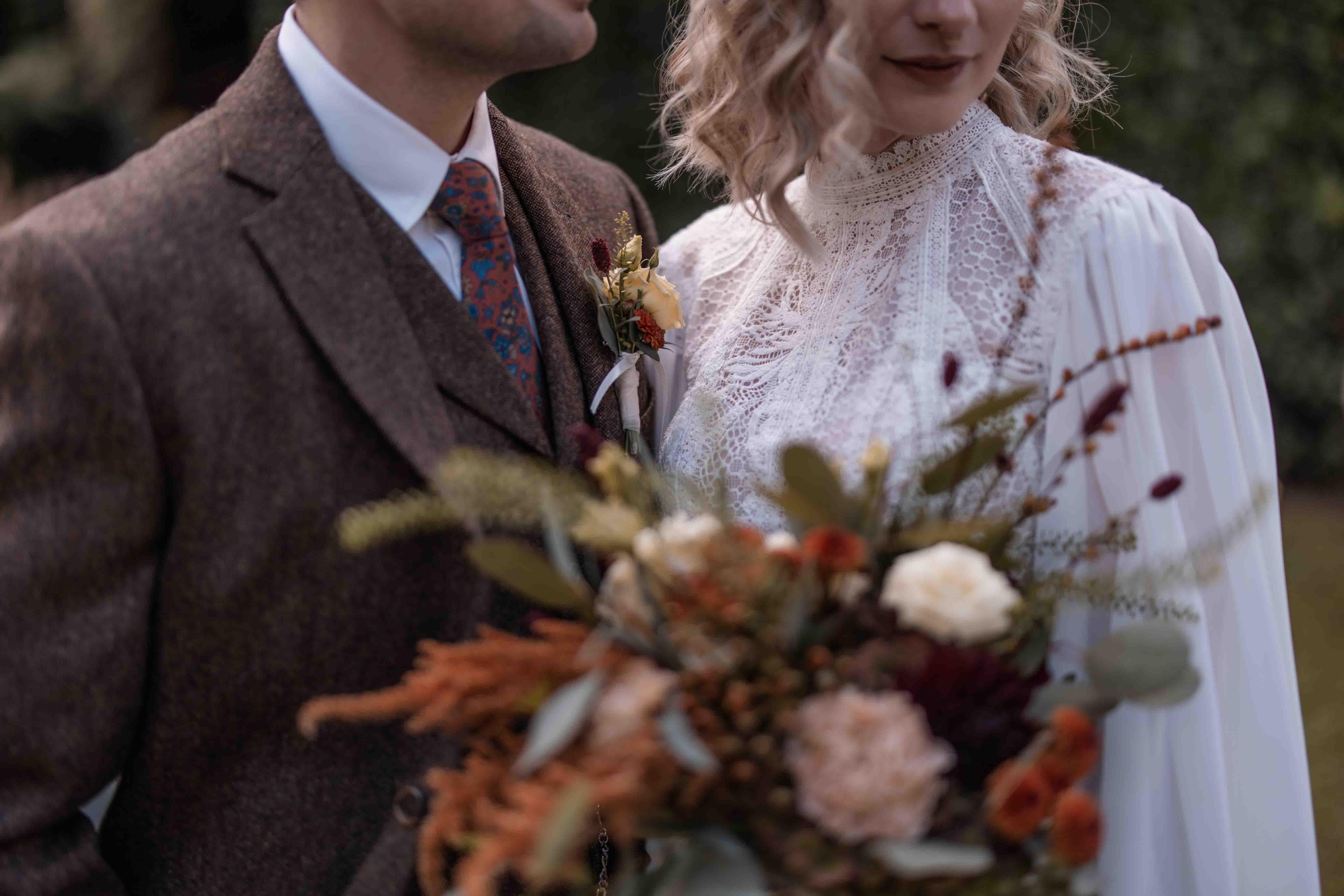 Hochzeitsfoto des Oberkörpers der Braut und Bräutigams mit Brautstrauß