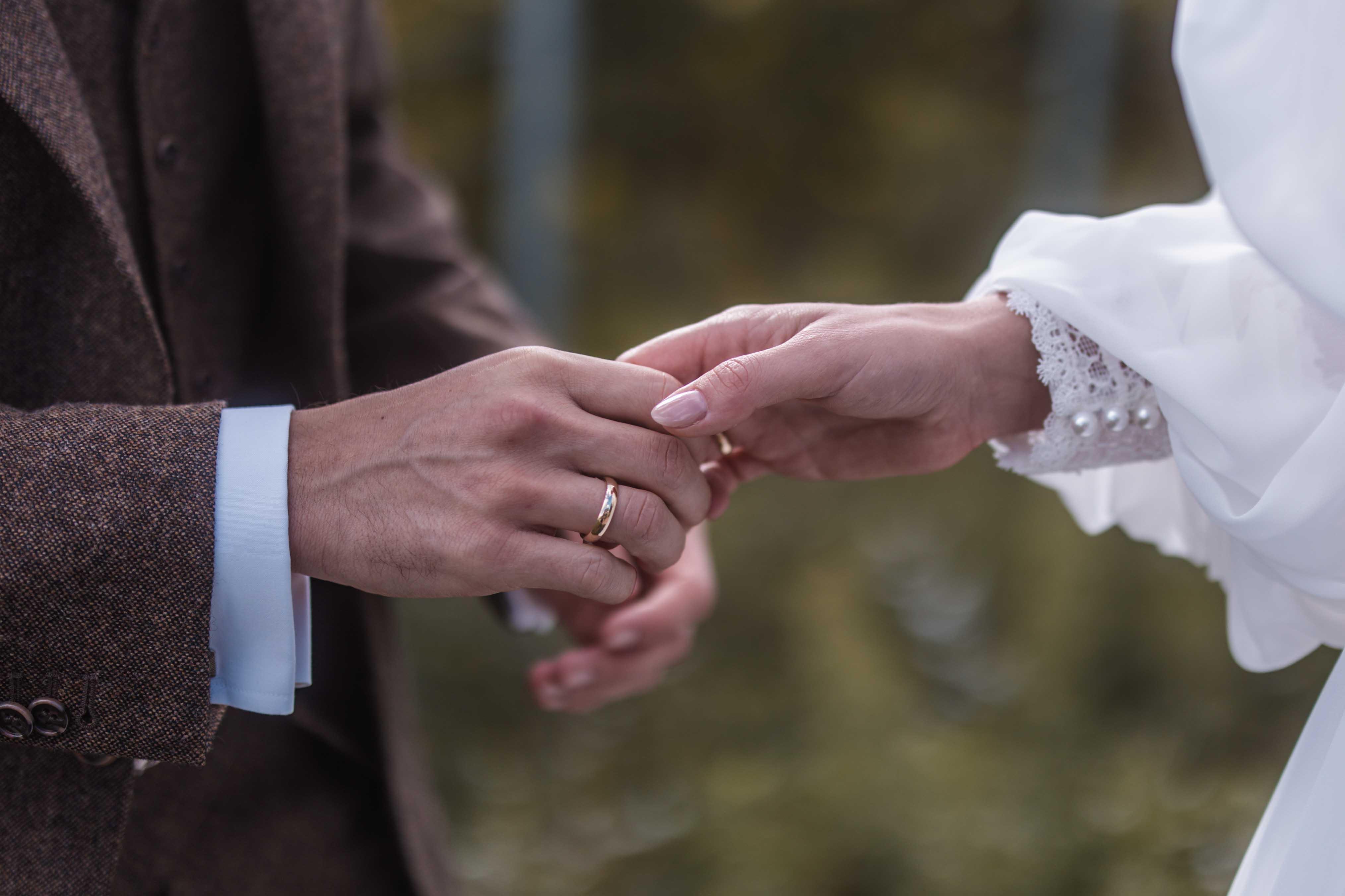 Hochzeitsfoto - Nahaufnahme der Hände des Brautpaars mit Ringen