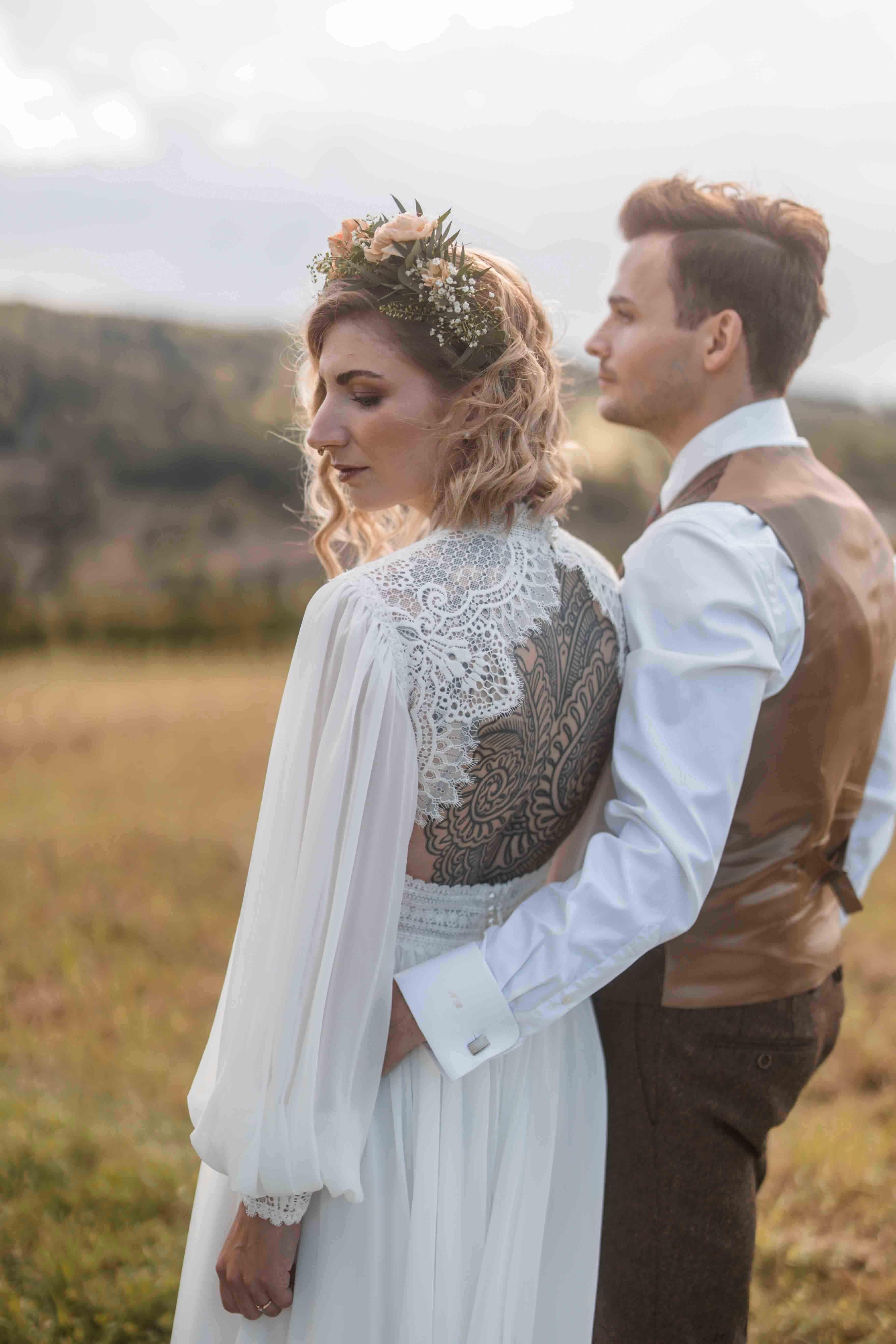Hochzeitsfoto mit Brautpaar fotografiert von hinten mit Blick in die Ferne