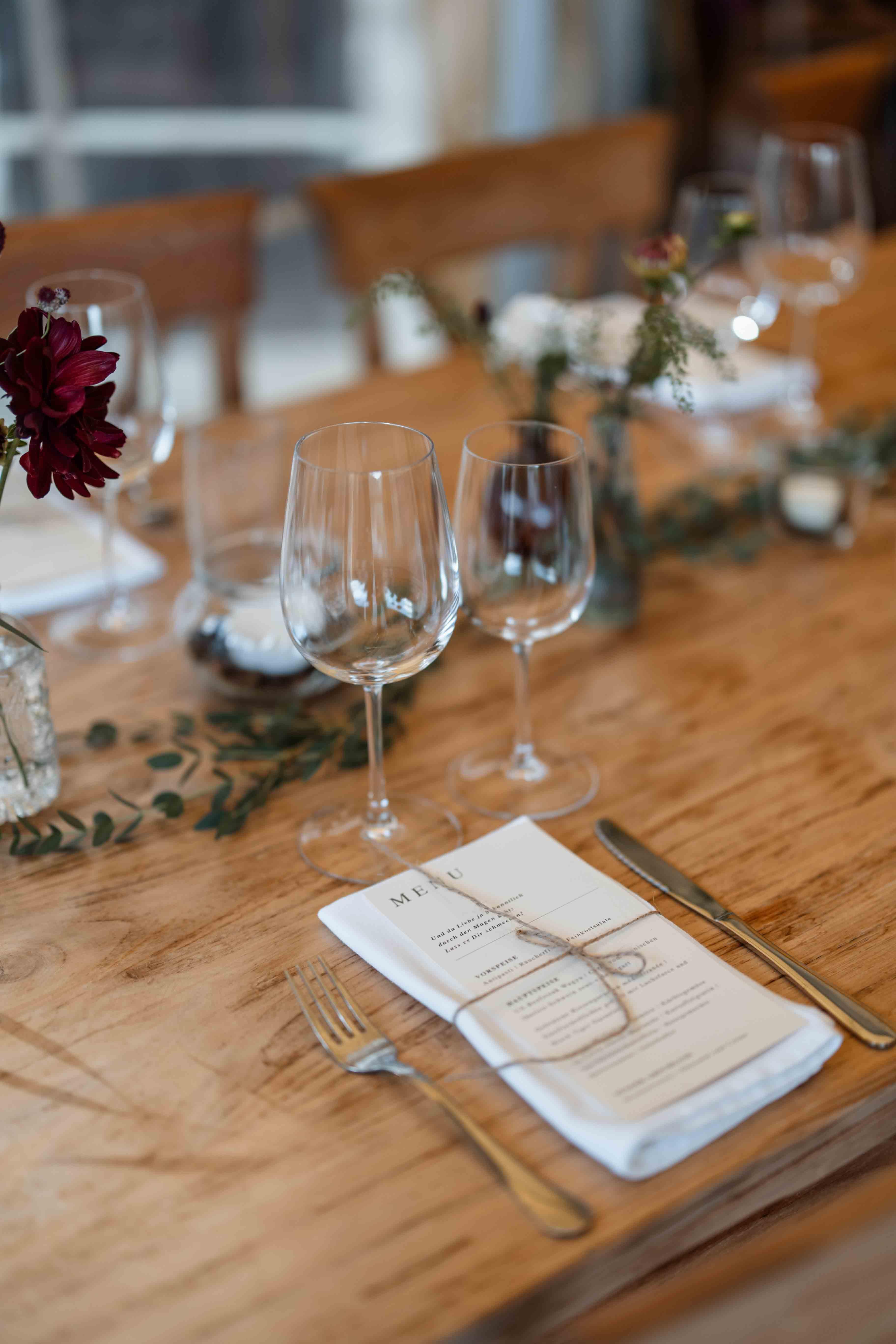 Fotografie der Dekoration - Tischgedeck mit Gläsern, der Speisekarte und Blumen