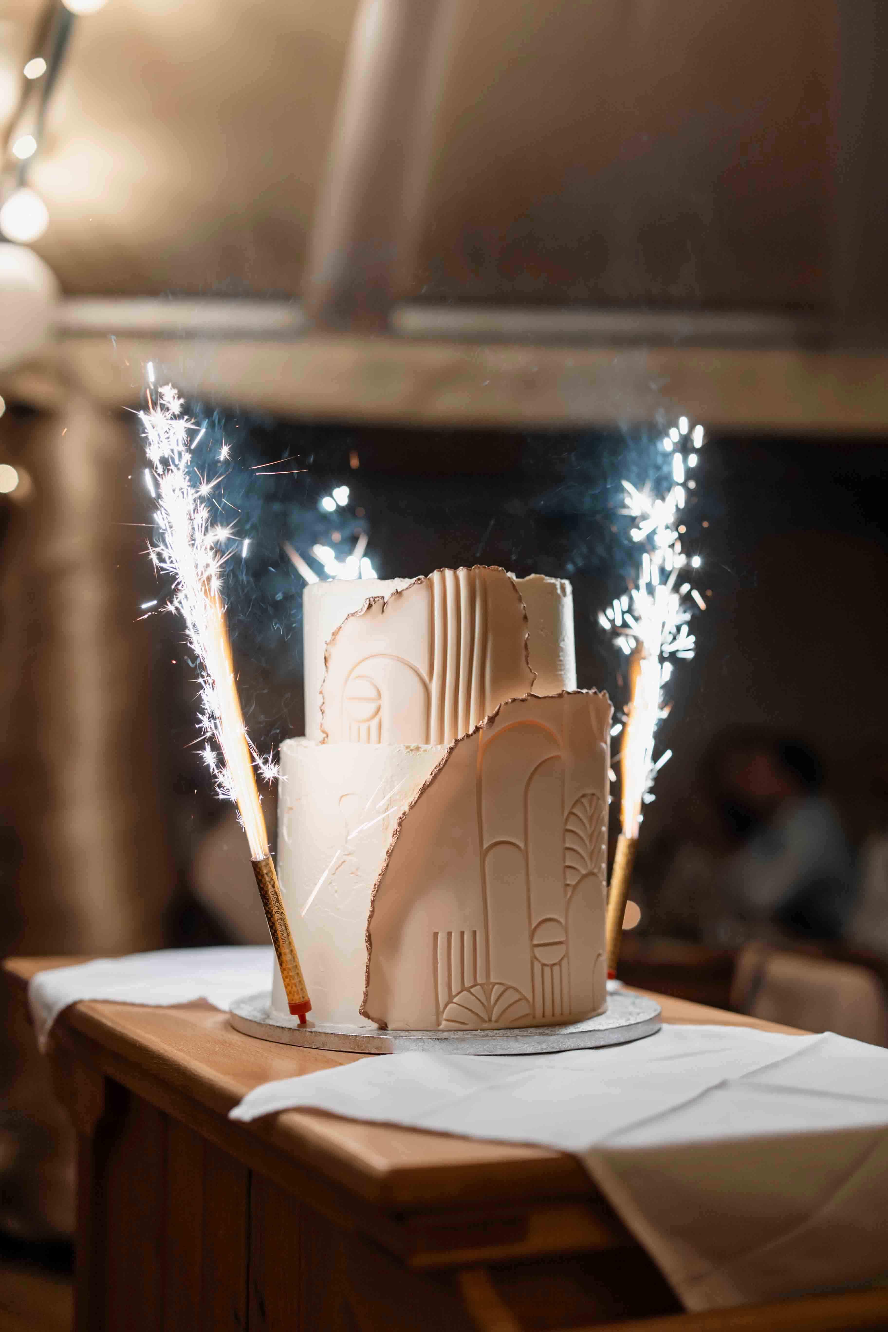 Fotografie der Hochzeitstorte mit kleiner Pyrotechnik neben der Torte