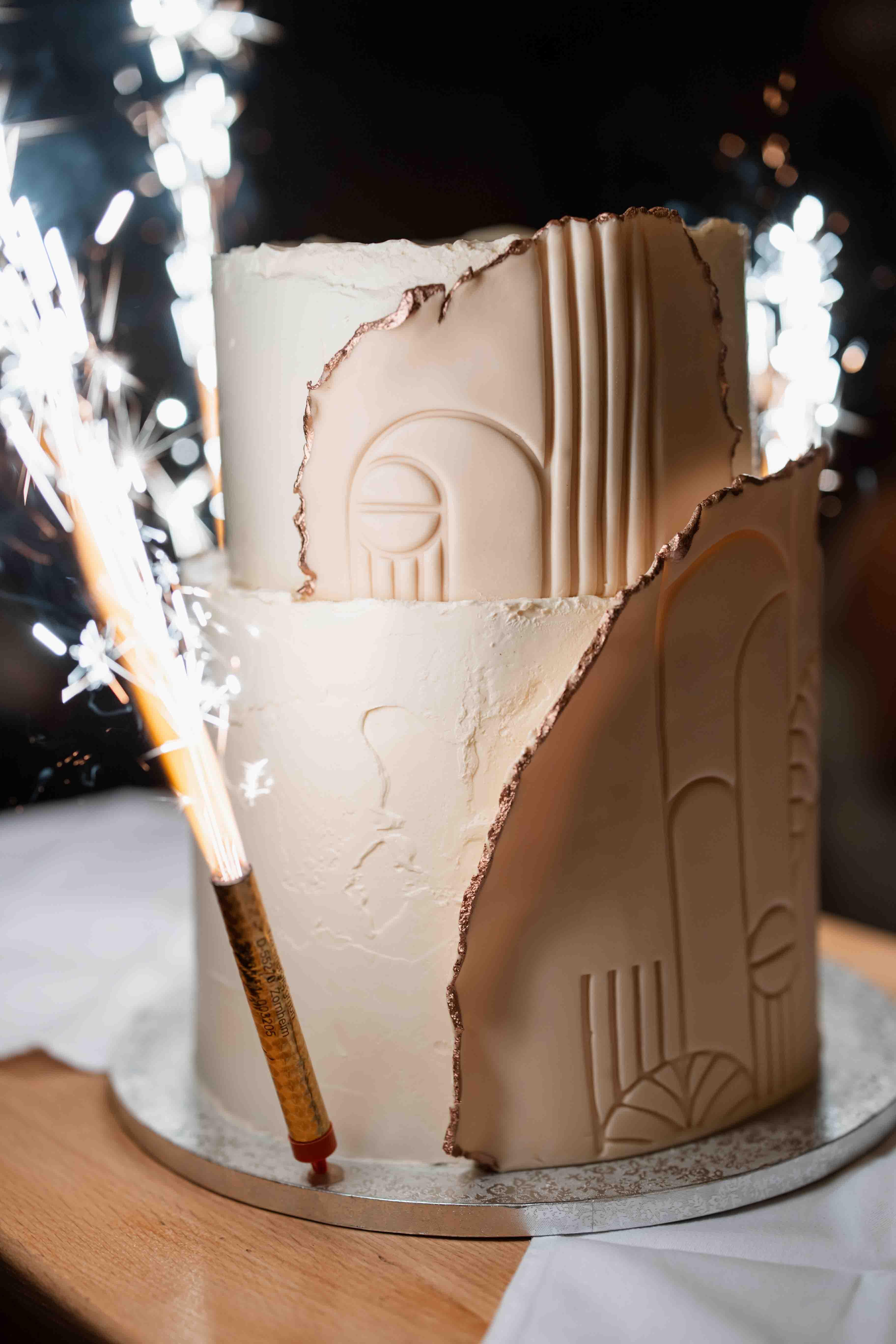 Fotografie der Hochzeitstorte mit kleiner Pyrotechnik neben der Torte in Nahaufnahme