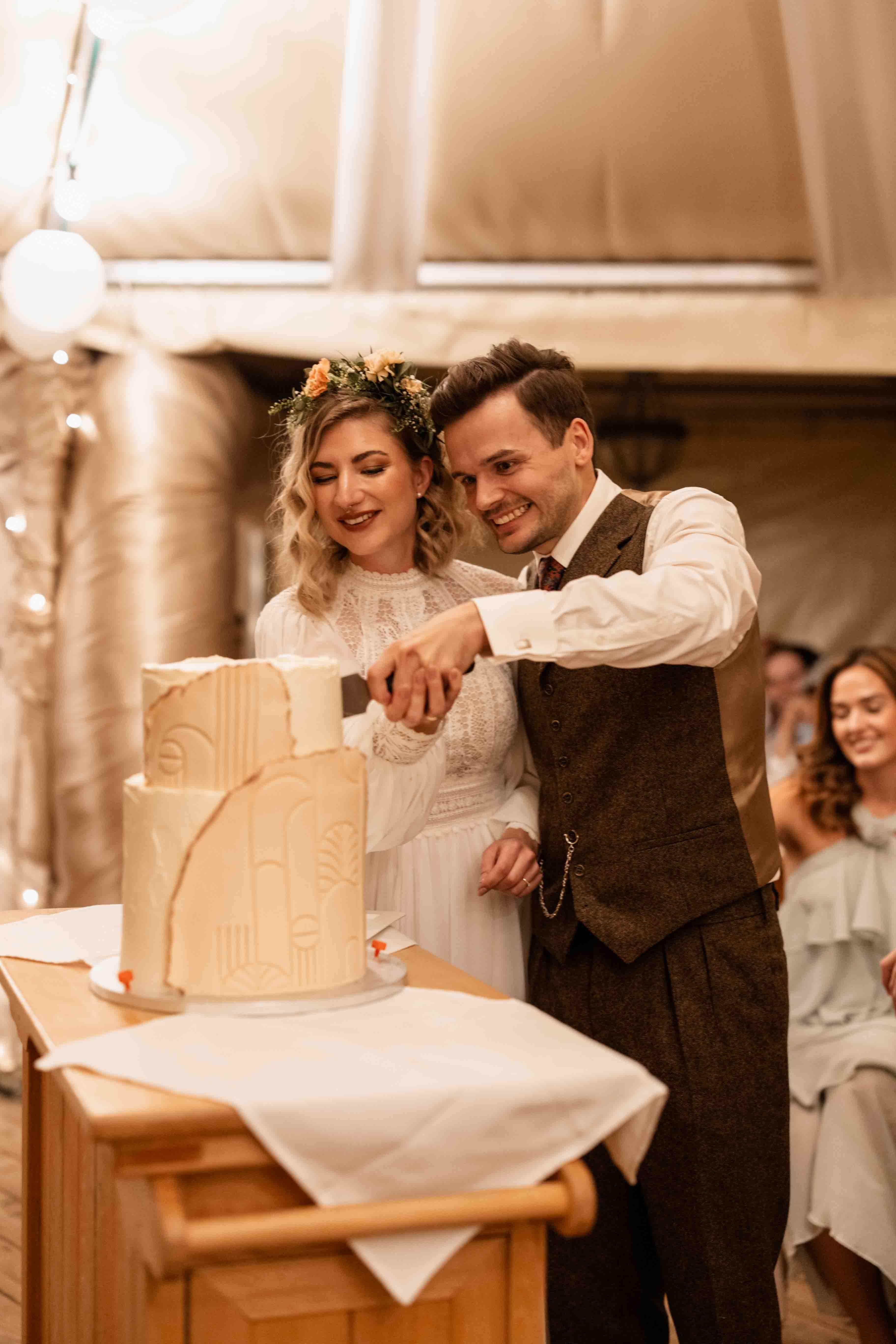 Hochzeitsfoto des Brautpaars beim Anschneiden der Hochzeitstorte