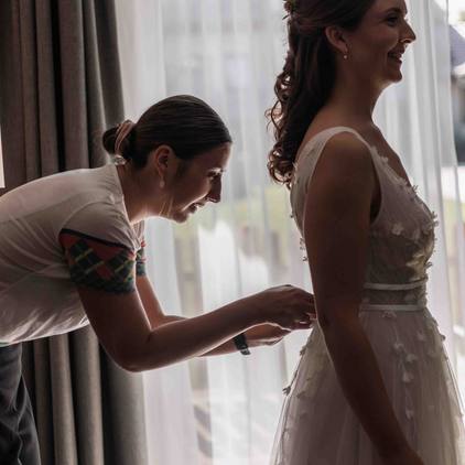 Hochzeitsfoto der Braut beim Getting-Ready und Ankleiden des Brautkleids