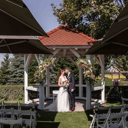 Hochzeitsfoto das Brautpaar küsst sich vor dem Gazebo bei der freien Trauung