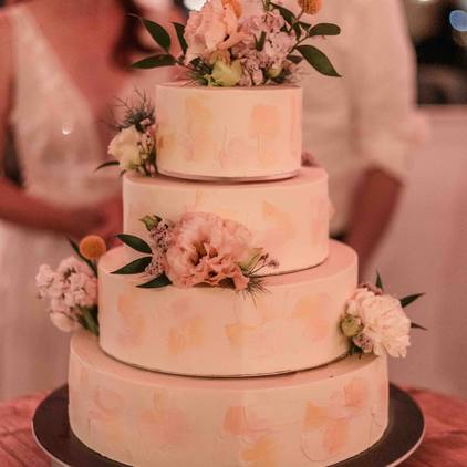 Hochzeitsfoto der Hochzeitstorte mit dem Brautpaar im Hintergrund unscharf