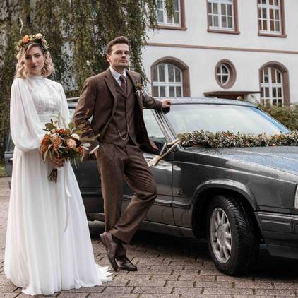 Hochzeitsfoto des Brautpaars mit Brautauto
