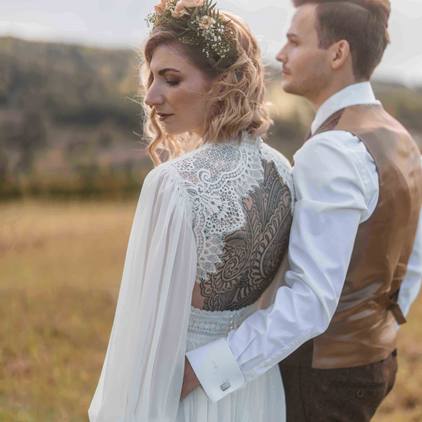 Hochzeitsfoto mit Brautpaar fotografiert von hinten mit Blick in die Ferne