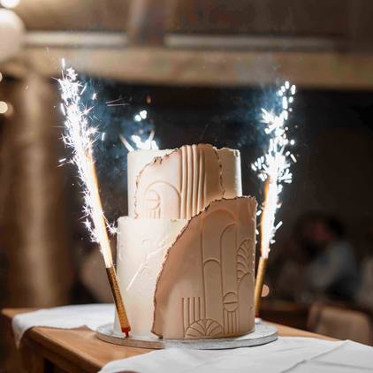 Fotografie der Hochzeitstorte mit kleiner Pyrotechnik neben der Torte