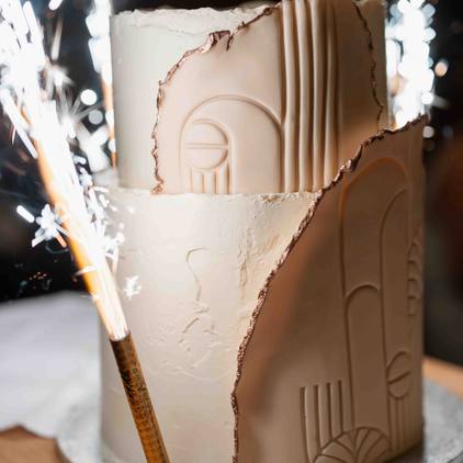 Fotografie der Hochzeitstorte mit kleiner Pyrotechnik neben der Torte in Nahaufnahme