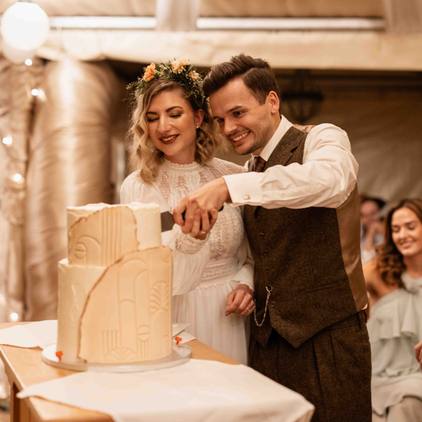 Hochzeitsfoto des Brautpaars beim Anschneiden der Hochzeitstorte